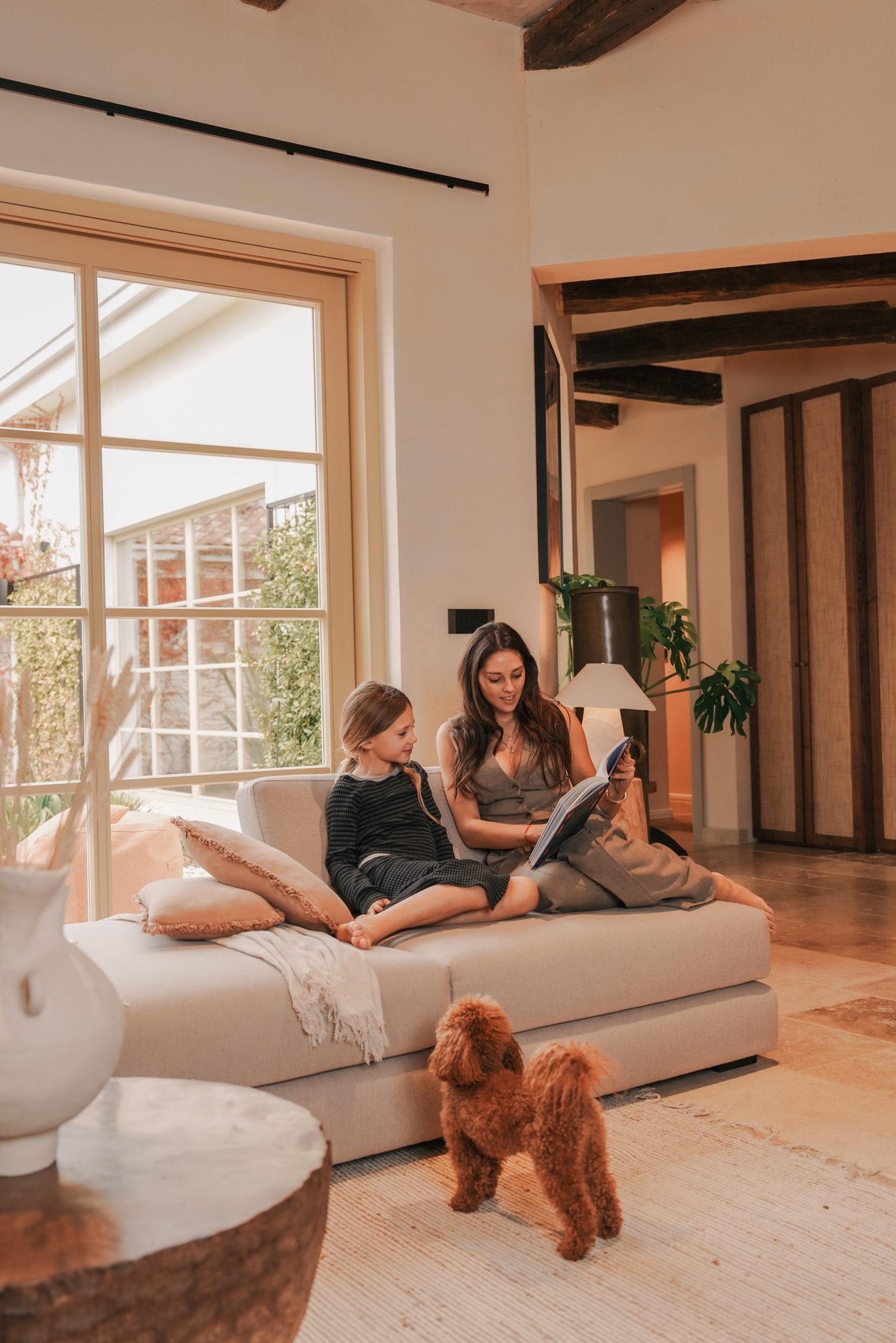 Eine Familie liest mit dem Hund im Wohnzimmer von LaMaison
