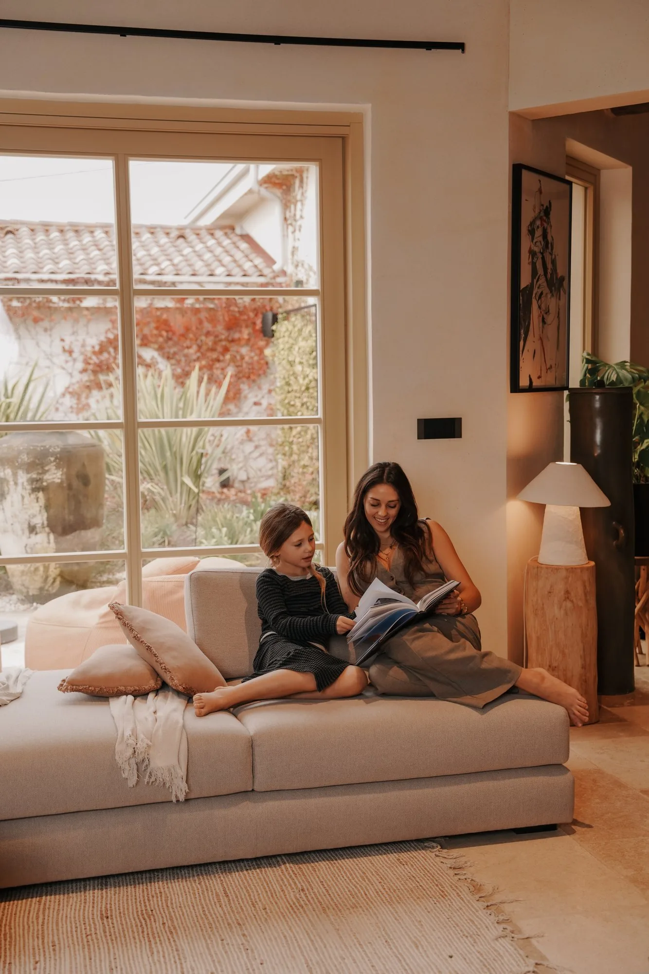 A mother and child reading on the sofa at LaMaison