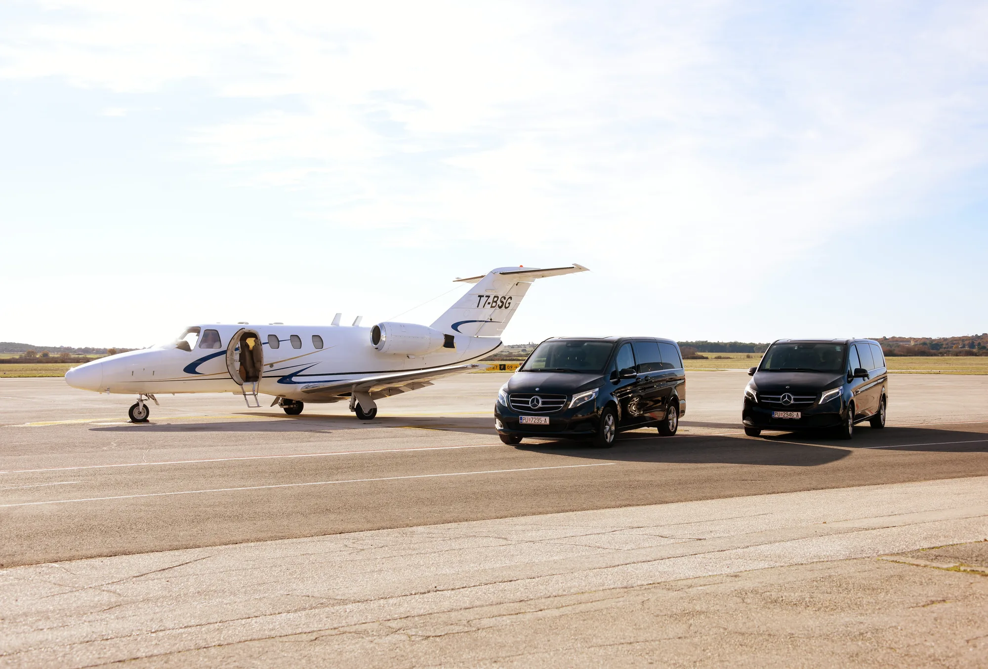 A private jet on the tarmac at Pula with a dark Mercedes van waiting, a Belistria transfer for LaMaison