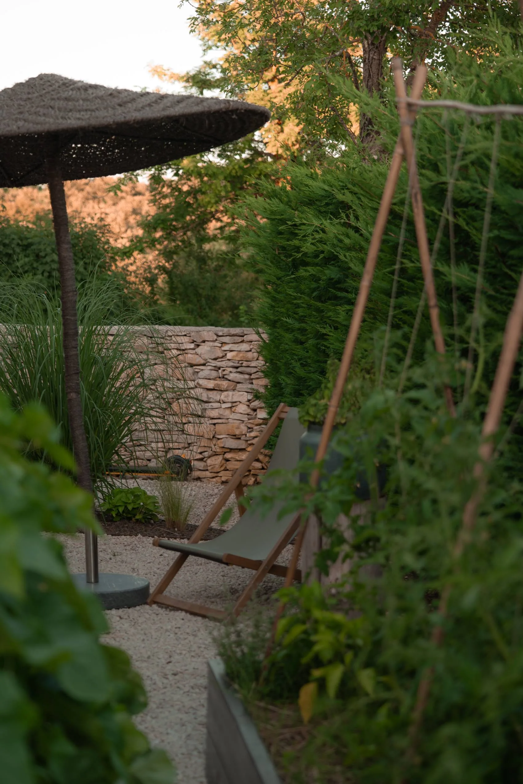 A deck chair by the dry stone wall in the garden at LaMaison