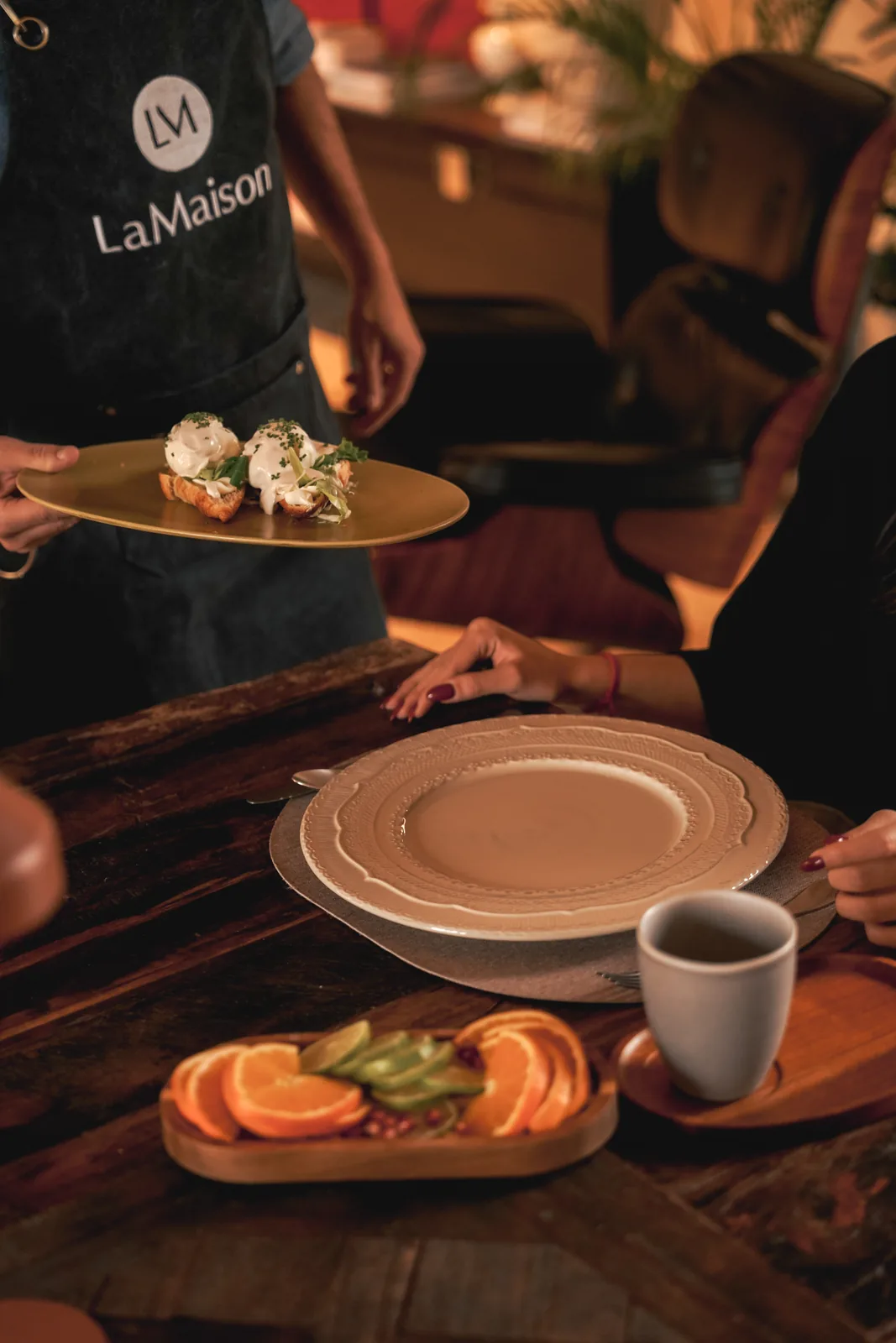 The chef bringing a dish to the table at LaMaison