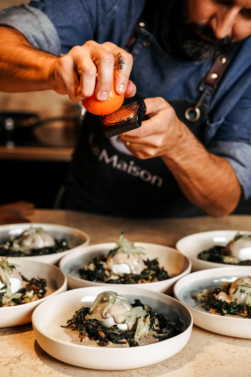 The chef finishing a dish by hand at LaMaison