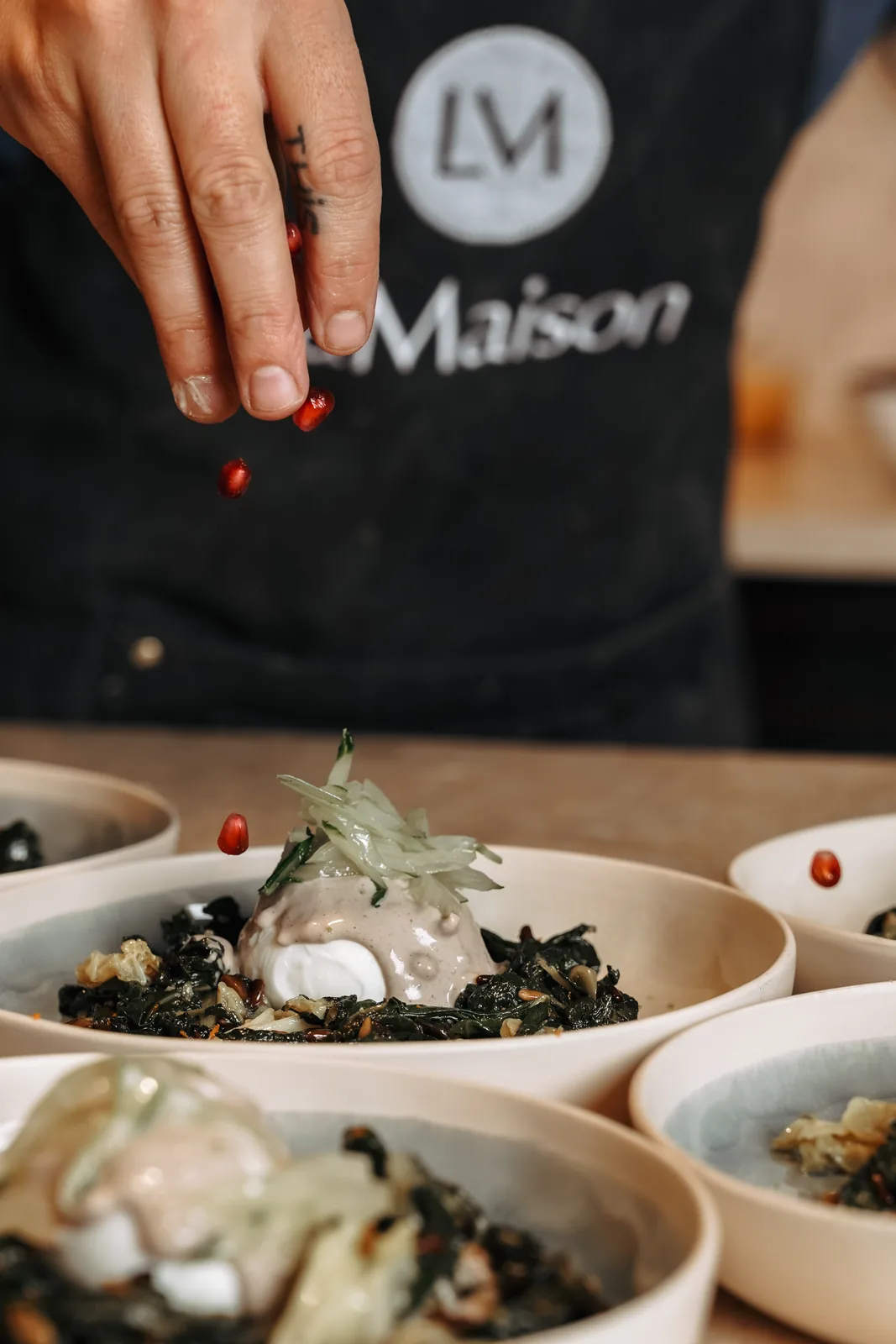 The chef seasoning a dish at LaMaison