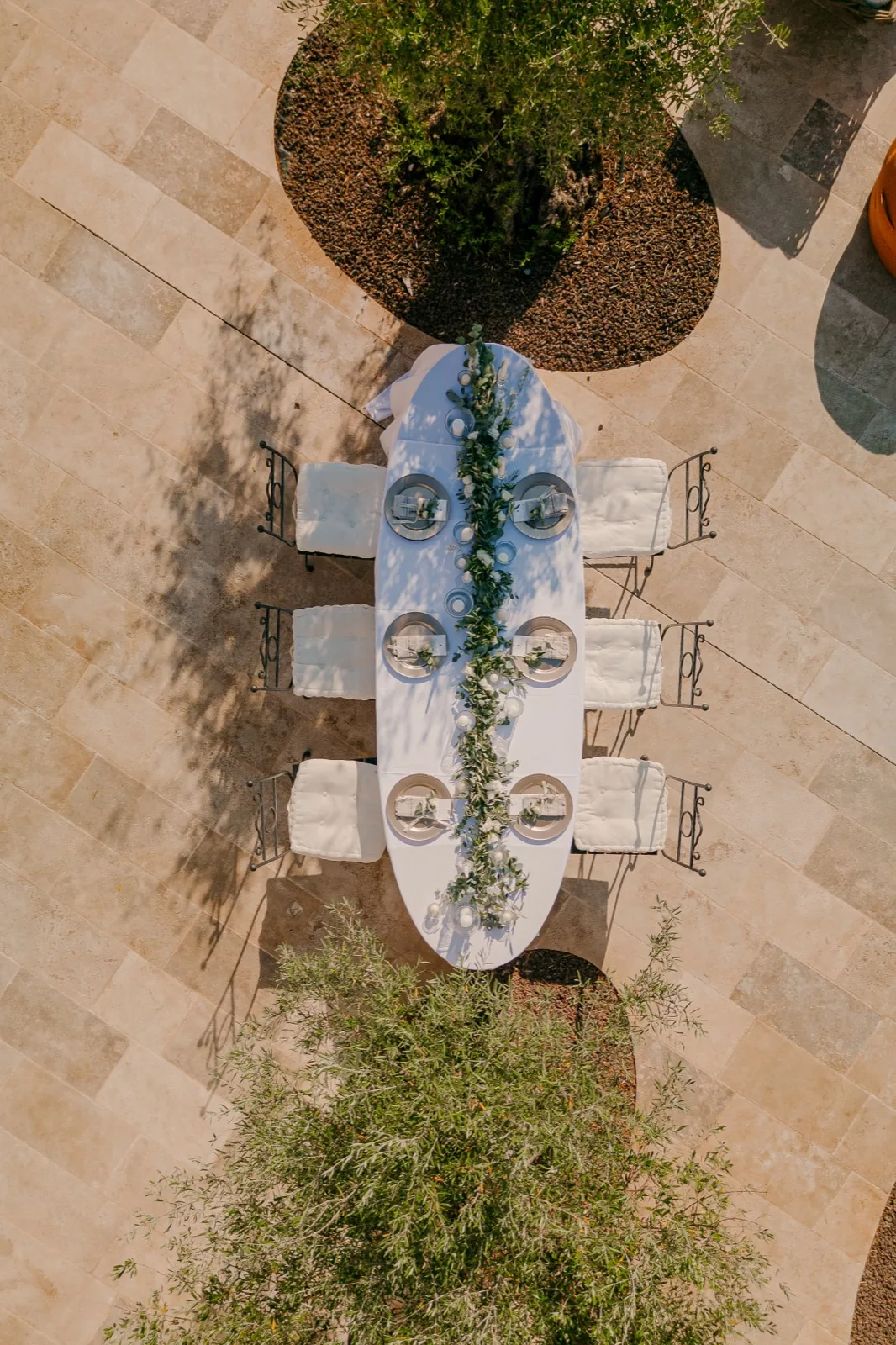An overhead view of a single long table at LaMaison, laid with a runner of greenery down its centre
